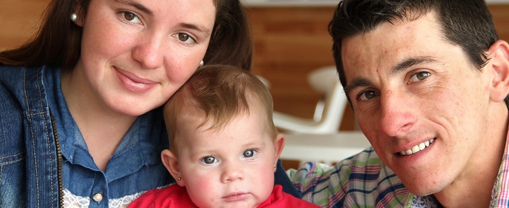 Padre, madre y su pequeña hija en medio de los dos.