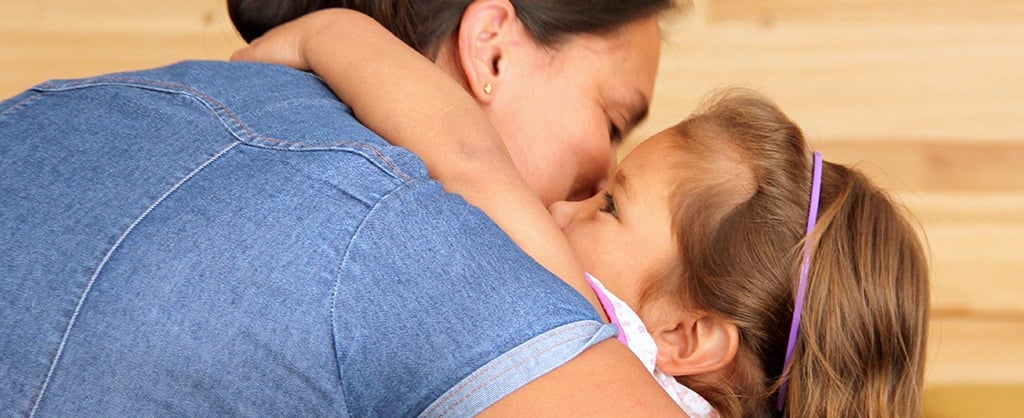 Madre abrazando a su pequeña hija.