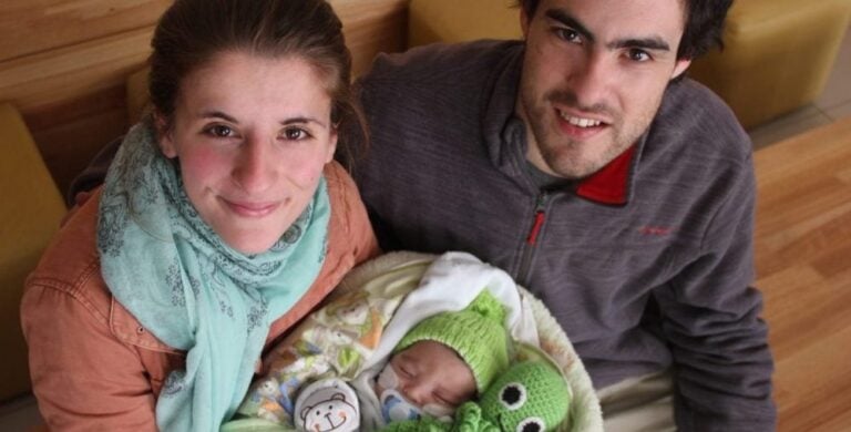 Mamá y papá sonrien junto a su bebé al ser dado de alta